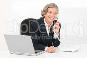 Senior businesswoman smile sit behind office desk