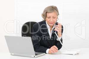 Senior businesswoman serious sit behind office desk