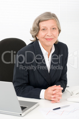 Senior businesswoman sit behind office desk