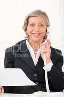 Senior businesswoman on phone hold empty sheet