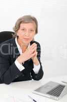 Senior businesswoman sit behind office desk