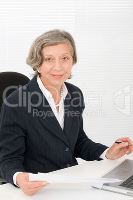 Senior businesswoman smile sit behind office desk