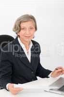 Senior businesswoman smile sit behind office desk