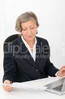 Senior businesswoman smile sit behind office desk