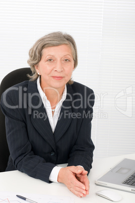 Senior businesswoman smile sit behind office desk