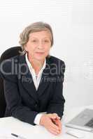 Senior businesswoman smile sit behind office desk