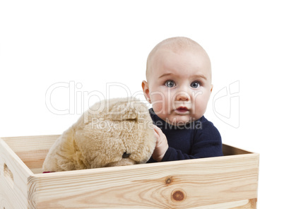 young child with toy in wooden box