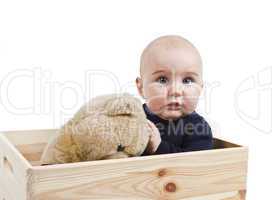 young child with toy in wooden box