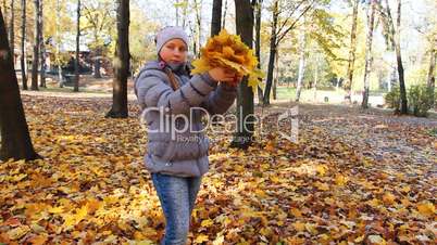 Girl Stands And Scatters Leaves