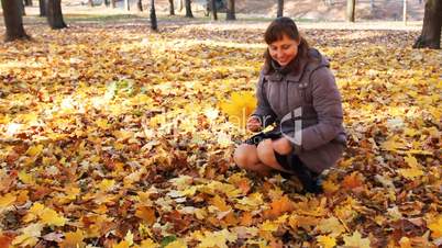 Woman Collects Leaves And Smiles