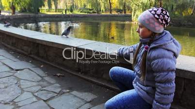 Girl Sits And Luring Pigeon