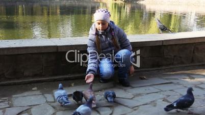 Girl Siting Feeds Pigeons