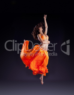 beauty dancer jump in orange veil - arabian style