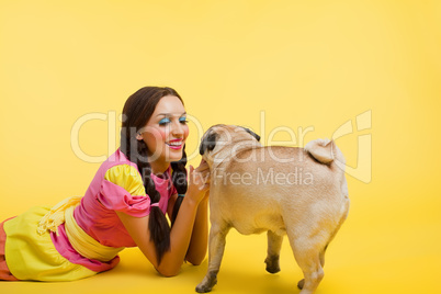 Happy wwoung woman in doll dress feed a small dog