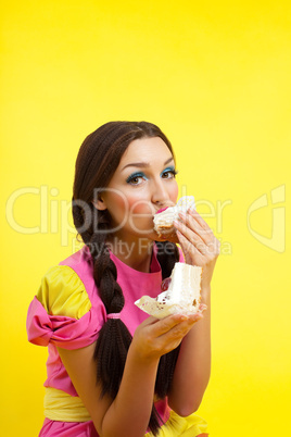 Young woman eat two cake - pin-up doll style