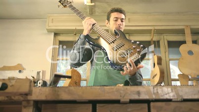 Adult man working as craftsman in guitar workshop