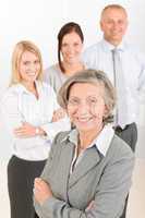 Businesswoman senior with colleagues in the back