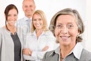 Businesswoman senior with colleagues in the back