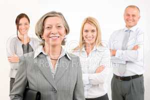 Businesswoman senior with colleagues in the back