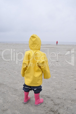 Mädchen im Friesennerz schaut zur Nordsee
