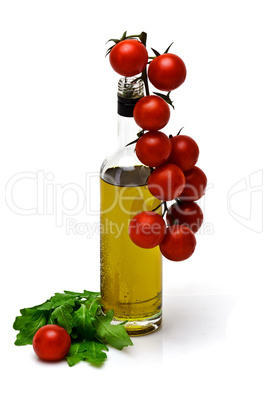 bottle of olive oil with cherry and arugula