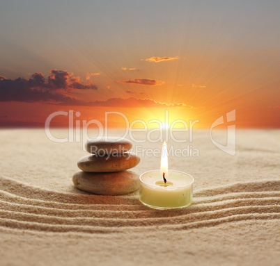 Stack of pebbles and light candle
