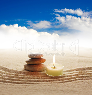 Stack of pebbles and light candle