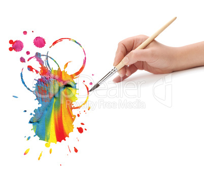 hand with artist brush and abstract paint blot