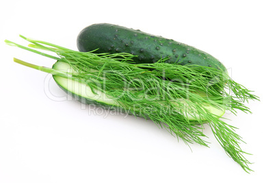 a cucumber with the cut half lying on a dill