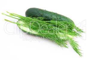 a cucumber with the cut half lying on a dill