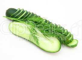 a cucumber with the cut half lying on a dill