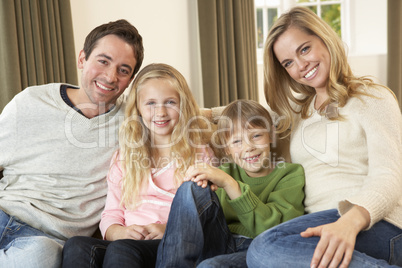 Happy young family sitting on sofa