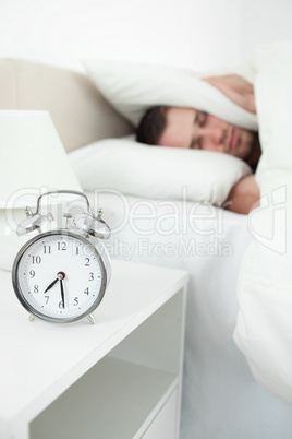 Portrait of a unhappy young man covering his ears with a pillow