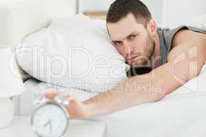 Man switching off his alarm clock