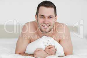 Smiling man lying on his bed