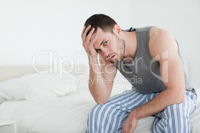 Young man sitting on his bed