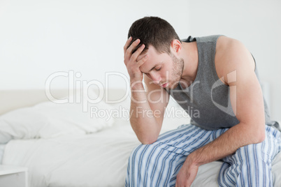 Exhausted man sitting on his bed