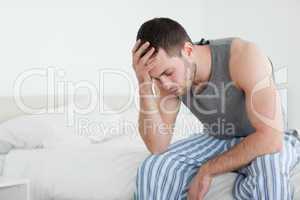 Exhausted man sitting on his bed