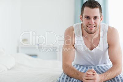 Happy man sitting on his bed