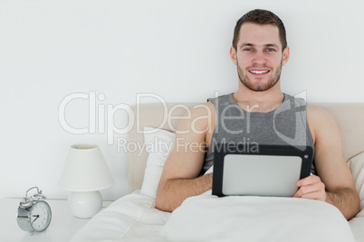 Calm man using a tablet computer