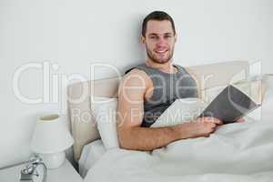 Smiling man reading a novel