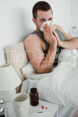 Portrait of a young man blowing his nose