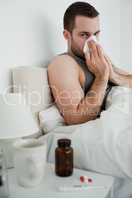 Portrait of an ill man blowing his nose