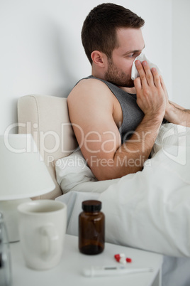 Portrait of a handsome man blowing his nose