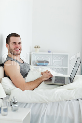 Portrait of a smiling man using a laptop