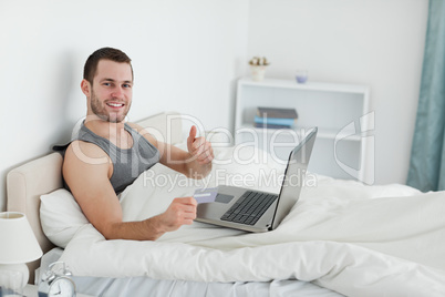 Happy man purchasing online with thumb up