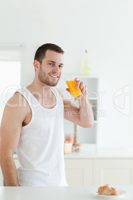 Portrait of a smiling man drinking orange juice