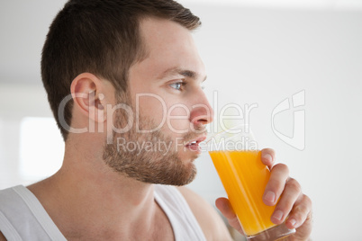 Close up of a healthy man drinking orange juice