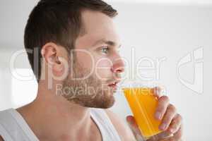 Close up of a healthy man drinking orange juice