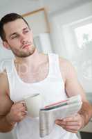 Portrait of a serious man drinking orange juice while reading th